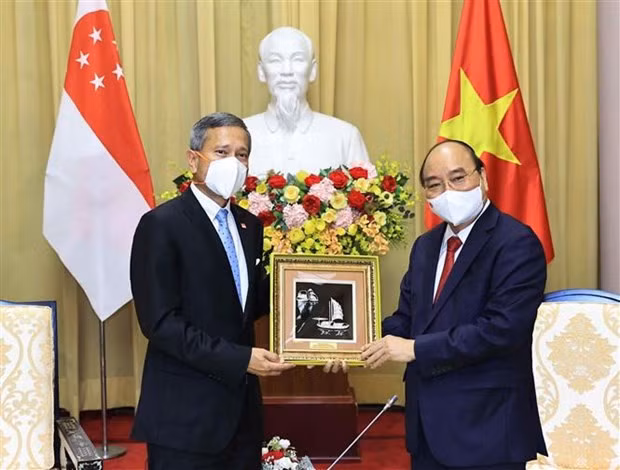 Chủ tịch nước Nguyễn Xuân Phúc trao đổi quà lưu niệm với Bộ trưởng Bộ Ngoại giao Cộng hòa Singapore Vivian Balakrishnan tại Phủ Chủ tịch, chiều 21/6/2021. (Ảnh: Thống Nhất/TTXVN)