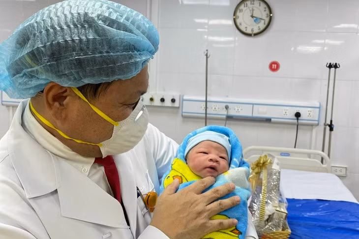 PGS.TS Trần Danh Cường- Giám đốc Bệnh viện Phụ sản Trung ương bế em bé sơ sinh chào đời đúng thời khắc Giao thừa năm Nhâm Dần tại phòng đẻ của Bệnh viện Ảnh: Thái Bình