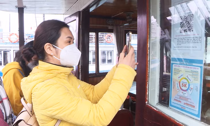 Du khách lên tàu tham quan Vịnh Hạ Long thực hiện việc quét mã QR để đảm bảo phòng, chống dịch hiệu quả.
