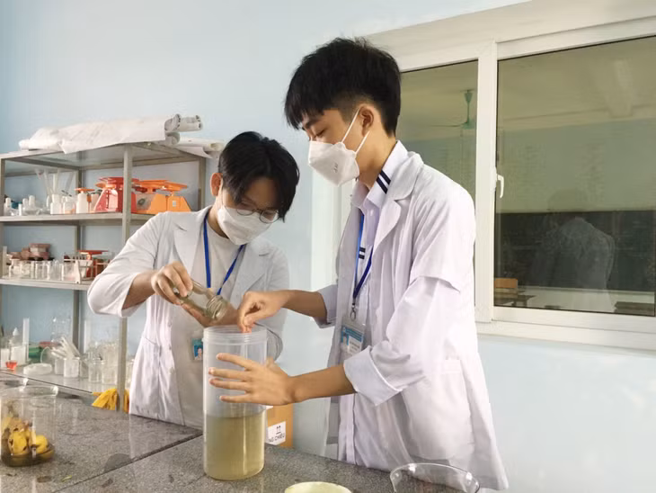 Nguyễn Trung Hiếu (phải) và Nguyễn Khải Gia (Trường THPT Uông Bí) pha dung dịch cao chiết từ bột lá húng quế khô.