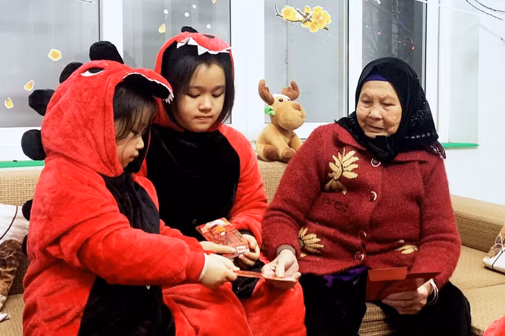 Sáng mùng 1 Tết, nhiều gia đình sum vầy bên nhau, bà mừng tuổi cho các cháu nhỏ, các cháu chúc ông bà, bố mẹ nhiều sức khỏe, bình an.
