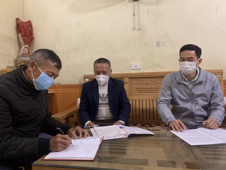Ông Nguyễn Đức Chính (bên trái) cùng cán bộ thôn, xã bàn biện pháp quản lý người dân về quê đón Tết Nguyên đán 2022.