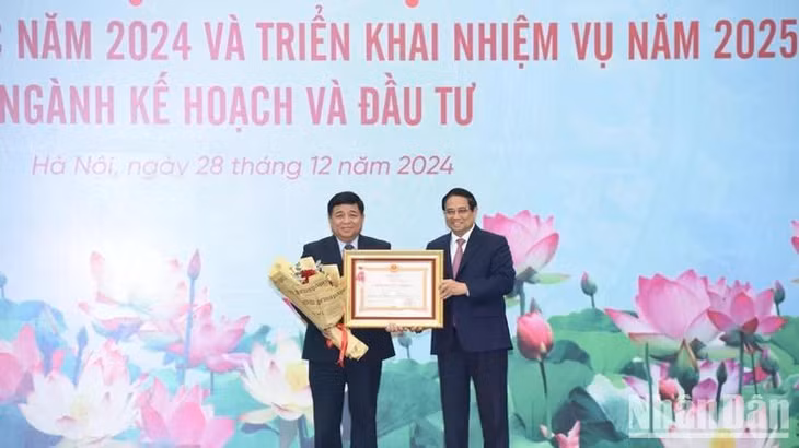 Thủ tướng Phạm Minh Chính trao Huân chương Lao động hạng Nhất tặng Bộ trưởng Kế hoạch và Đầu tư Nguyễn Chí Dũng. (Ảnh: TRẦN HẢI)