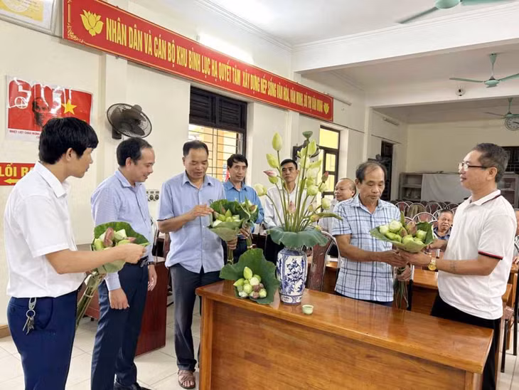 Đảng viên Chi bộ khu Bình Lục Hạ (phường Hồng Phong, TP Đông Triều) trao đổi cùng lãnh đạo phường Hồng Phong về chuyển đổi diện tích trồng lúa kém hiệu quả sang trồng sen. Ảnh: Trúc Linh