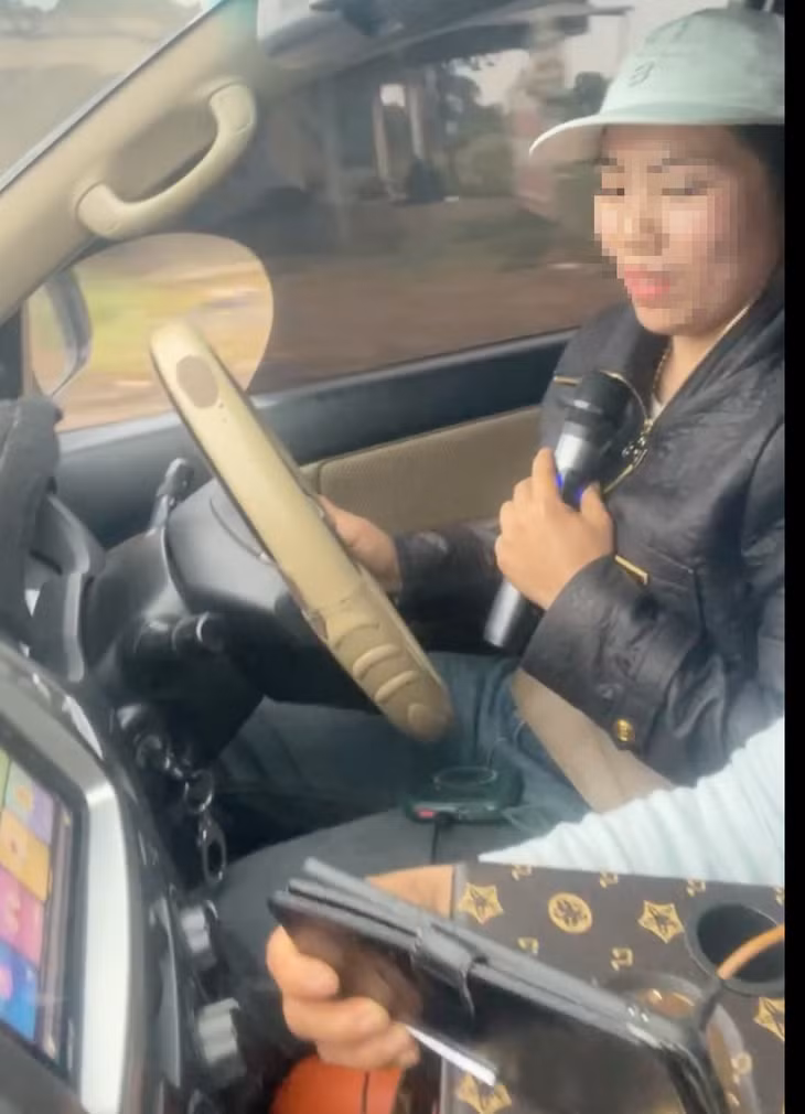 Công an hai tỉnh Đắk Lắk, Đắk Nông đang xác minh người phụ nữ vừa lái xe vừa hát karaoke trên quốc lộ 14 - Ảnh cắt từ clip