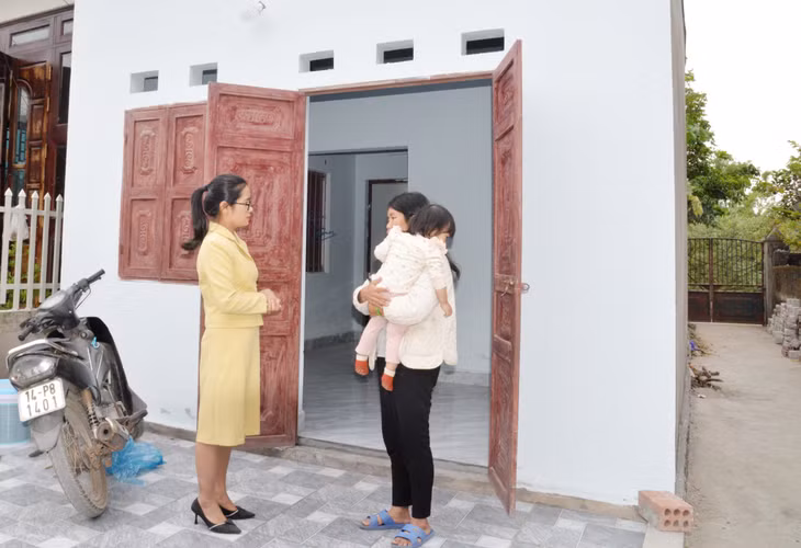 Bà Đặng Thị Mai Hạnh, hộ cận nghèo ở thôn Cây Sằm, xã Tiền An bên ngôi nhà mới được cấp ủy, chính quyền địa phương hỗ trợ xây dựng. 
