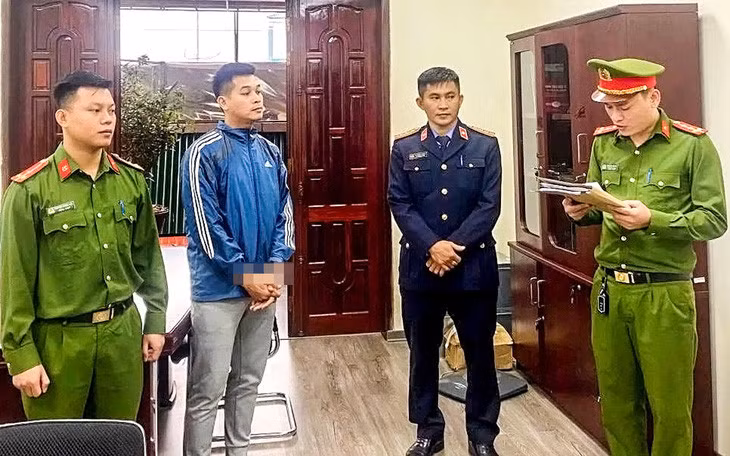 Võ Hoàng Long (thứ 2 từ trái sang) nghe tống đạt các quyết định tố tụng từ cơ quan công an - Ảnh: Công an cung cấp
