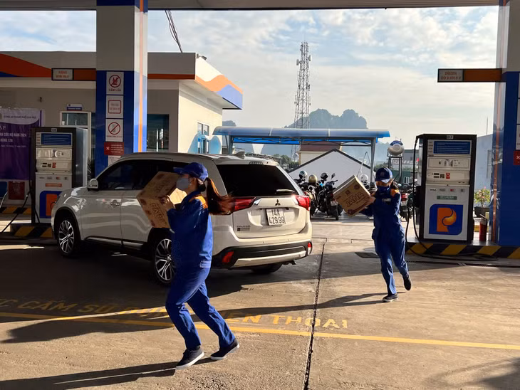 Nhân viên cửa hàng xăng dầu di chuyển đồ đạc ra khỏi khu vực gặp sự cố.