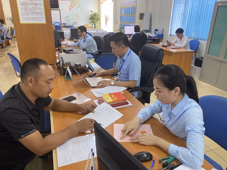 Cán bộ Trung tâm Hành chính công huyện Vân Đồn hướng dẫn công dân làm TTHC.