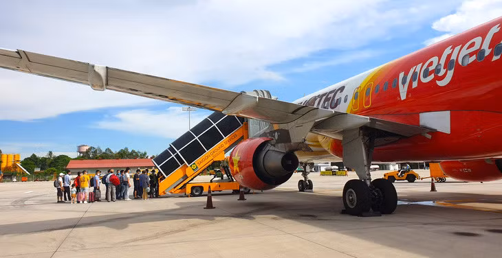 Người dân di chuyển lên máy bay Vietjet - Ảnh: HỒNG PHÚC