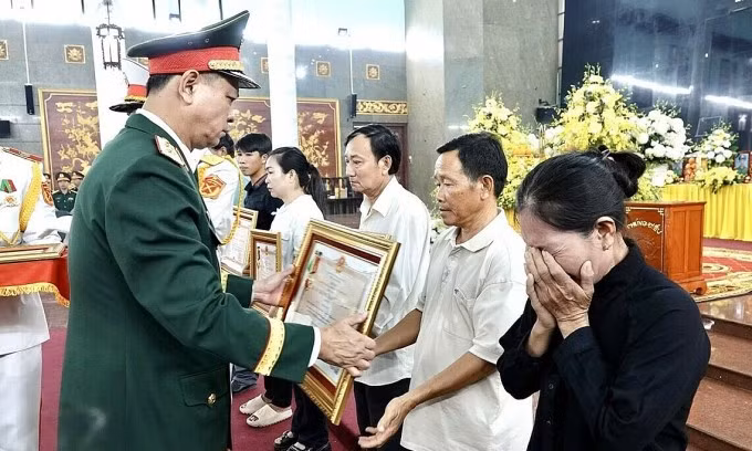 Trung tướng Nguyễn Trường Thắng, Tư lệnh Quân khu 7, trao Huân chương Bảo vệ Tổ quốc hạng Ba cho thân nhân 12 liệt sĩ. Ảnh: Lê Tuyết