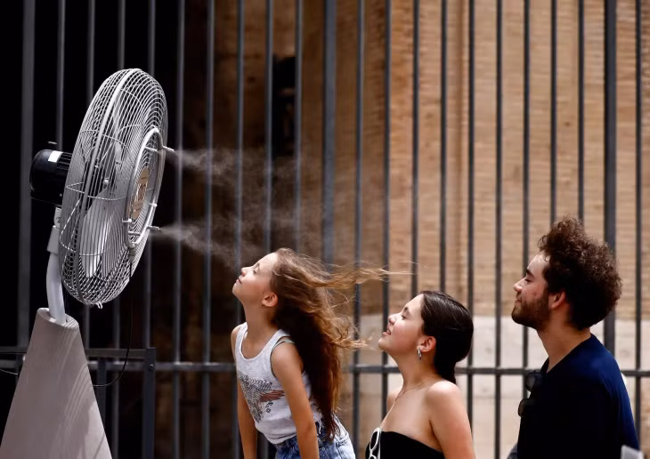 Nhóm du khách hưởng làn gió mát từ máy quạt được trang bị tại Đấu trường La Mã (Rome, Italy) ngày 21/6. Ảnh: Yara Nardi/Reuters.