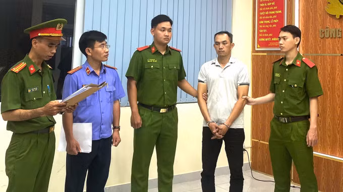 Cảnh sát đọc lệnh bắt Bùi Thanh Khoa. Ảnh: Công an cung cấp