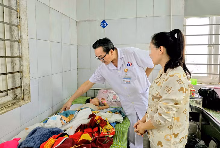 Bác sĩ Thái Văn Bình - Trưởng khoa Chấn thương - Bỏng, Bệnh viện Sản Nhi Nghệ An kiểm tra tình trạng của bệnh nhi sau 2 lần ghép da do bỏng. Ảnh minh họa: INT.