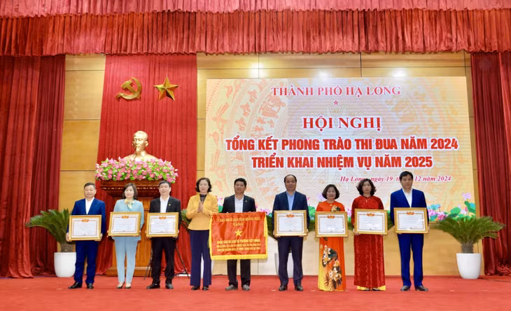 Đồng chí Vũ Thị Mai Anh, Phó Bí thư Thường trực Thành ủy, Chủ tịch HĐND thành phố, trao Cờ thi đua và Bằng khen của UBND tỉnh cho các tập thể có thành tích xuất sắc trong công tác và phong trào thi đua năm 2024.