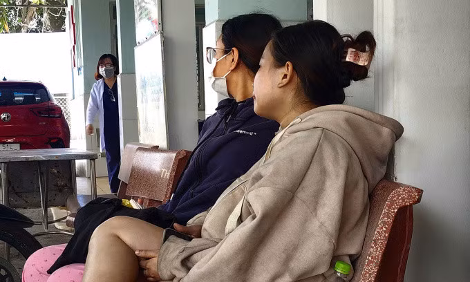 Quần áo, khuôn mặt chị Trân bị ám khói đen ngồi tại Trạm y tế phường Tăng Nhơn Phú B sau khi được chăm sóc y tế. Ảnh: Đình Văn