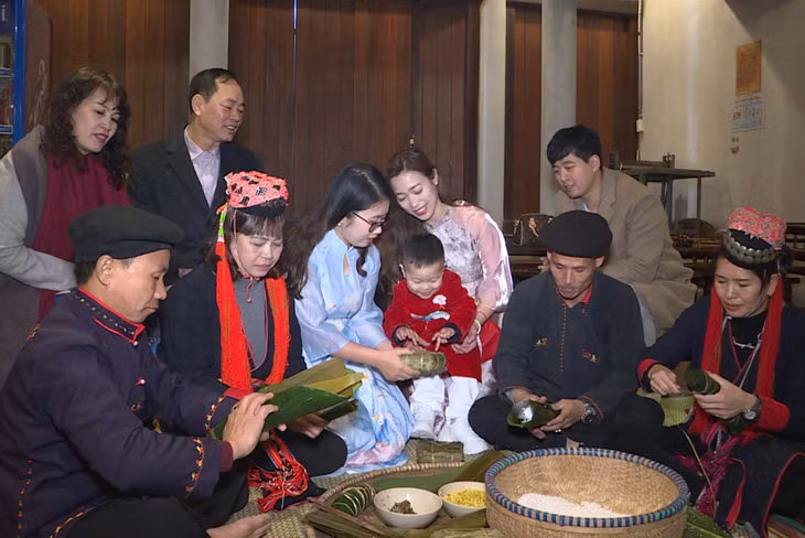 Du khách trải nghiệm gói bánh chưng tại làng Nương Yên Tử. 