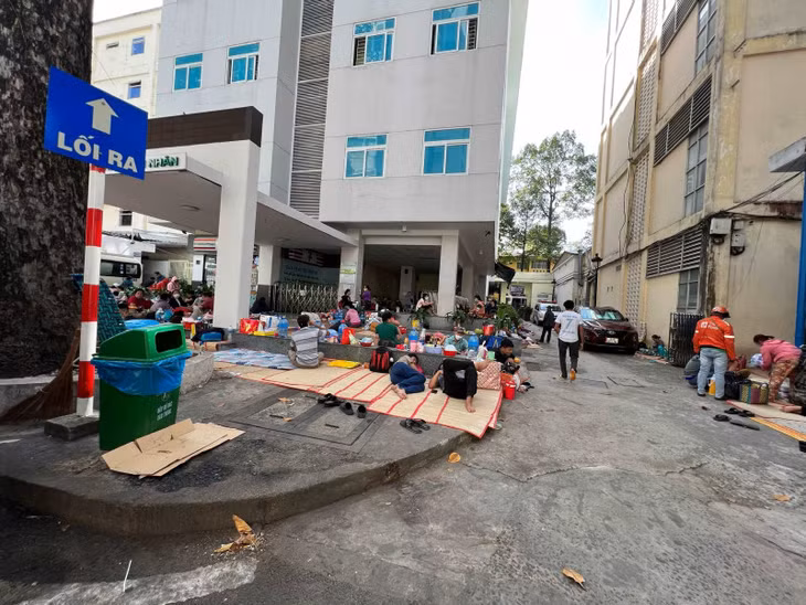 Người nhà bệnh nhân trải chiếu nằm ở bên ngoài khu E, BV Chợ Rẫy.