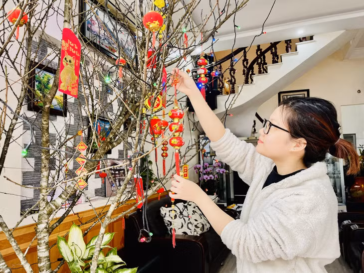 Người dân phấn khởi trang trí cành đào chuẩn bị đón Xuân sang.