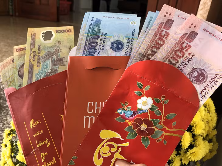 Nhiều bố mẹ đưa tiền mừng tuổi của con ra tính lỗ lãi. Ảnh: Anh Huy.