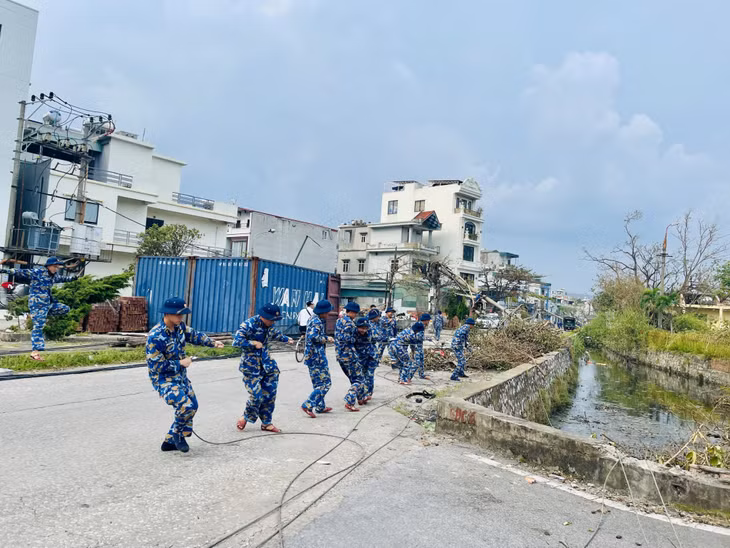 Các chiến sĩ của Lữ đoàn 170 và Trung tâm huấn luyện chuyên môn kỹ thuật nghiệp vụ vùng 1 Hải quân thực hiện thu hồi dây điện của cột điện 35kV tại khu vực phường Hồng Hà (TP Hạ Long) bị gãy, đổ.