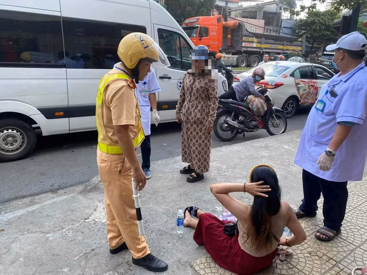 Lực lượng chức năng cùng gia đình đưa người phụ nữ đến bệnh viện - Ảnh: H.B.