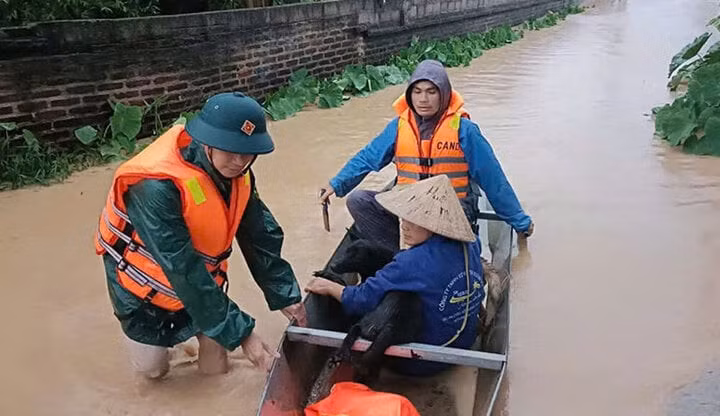 Cán bộ, chiến sĩ lực lượng vũ trang huyện Sơn Động giúp người dân thị trấn An Châu di chuyển khỏi vùng ngập lụt. (Ảnh: Báo Bắc Giang)