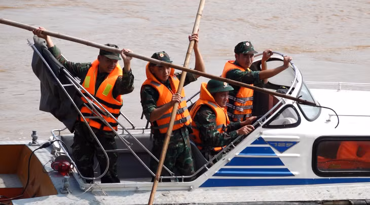 Lực lượng chức năng tìm kiếm nạn nhân trong vụ sập cầu Phong Châu - Ảnh: DƯƠNG LIỄU