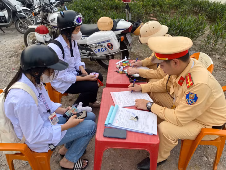 Lực lượng CSGT Công an TP Hạ Long lập biên bản và nhắc nhở học sinh vi phạm Luật Giao thông đường bộ.