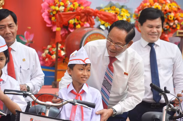 Học sinh khó khăn tại Trường THCS Ba Vì hạnh phúc khi được Phó chủ tịch Quốc hội Trần Quang Phương tặng xe đạp - Ảnh: T.M.