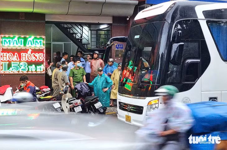 Lực lượng chức năng phối hợp đưa trẻ từ mái ấm Hoa Hồng trên đường Tô Ký (phường Trung Mỹ Tây, quận 12) đến cơ sở bảo trợ xã hội công lập - Ảnh: NGỌC KHẢI