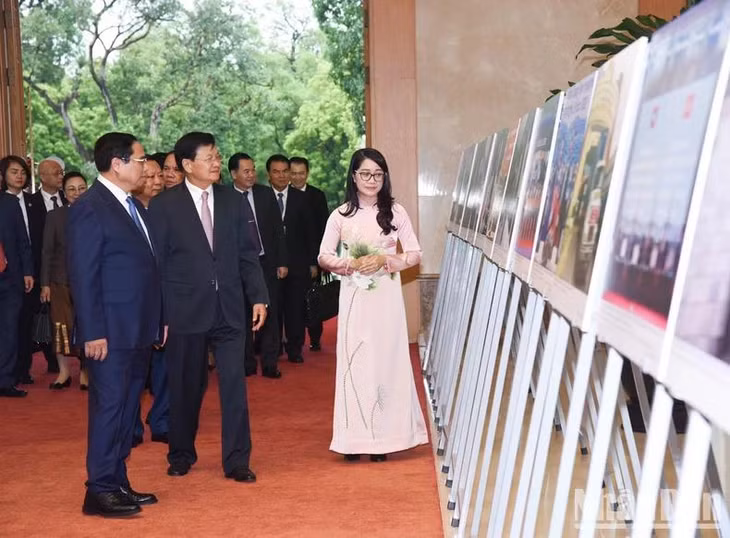 Thủ tướng Phạm Minh Chính giới thiệu với Tổng Bí thư, Chủ tịch nước Lào Thongloun Sisoulith những bức ảnh nói về quan hệ hữu nghị đặc biệt hai nước. (Ảnh: TRẦN HẢI)
