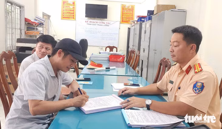 Cảnh sát giao thông làm việc với tài xế Thắng - Ảnh: HOÀI THƯƠNG