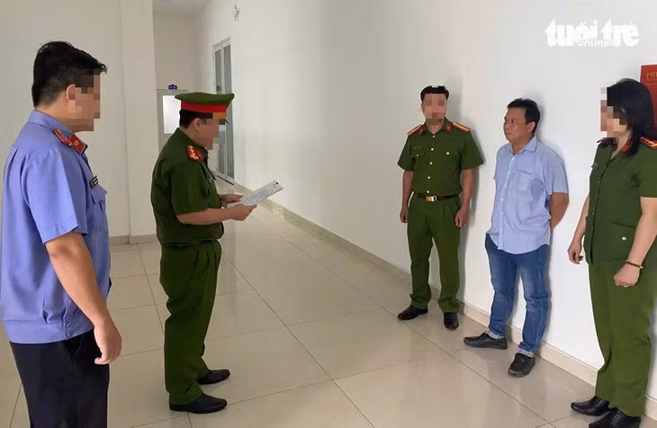Công an tống đạt quyết định khởi tố, cấm đi khỏi nơi cư trú đối với chủ doanh nghiệp - Ảnh: T.D.