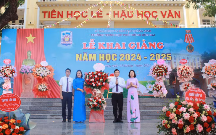 Đồng chí Nghiêm Xuân Cường, Phó Chủ tịch UBND tỉnh tặng hoa chúc mừng năm học mới thầy và trò Trường THPT Hòn Gai.
