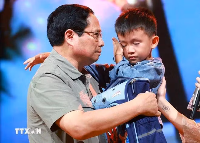 Thủ tướng Phạm Minh Chính động viên cháu Nguyễn Quốc Bảo (sinh năm 2016) bị mất cả bố và chị gái khi 3 người bị nước lũ cuốn trôi trong lúc di chuyển bằng xe máy qua cầu tràn thôn Cầu Treo, xã Yên Thuận, huyện Hàm Yên, tỉnh Tuyên Quang. (Ảnh: Dương Giang/TTXVN)
