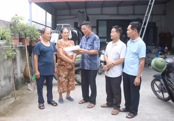 Ông Tạ Văn Vui cùng cán bộ tổ dân, khu phố hướng dẫn các hộ dân thống kê thiệt hại về nhà cửa sau cơn bão số 3.