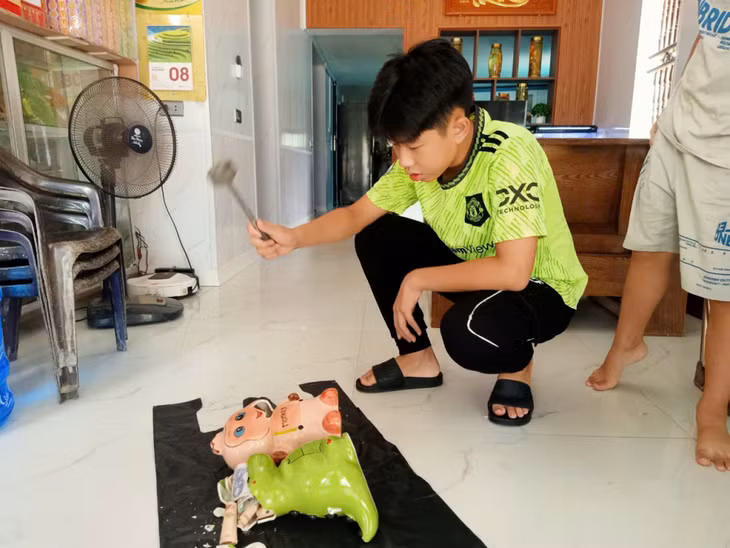 Hai anh em đập lợn đất ủng hộ các bạn học sinh vùng lũ.