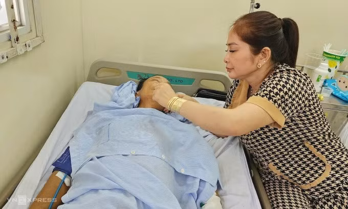 Bà Quyên chăm sóc chồng ở Bệnh viện Lê Văn Thịnh, chiều 14/2. Ảnh: Đình Văn