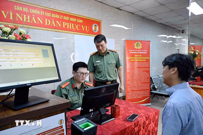 Cán bộ, chiến sỹ Cục quản lý xuất nhập cảnh, Bộ Công an tiếp nhận nhập thông tin người nước ngoài cung cấp vào hệ thống định danh và xác thực điện tử. (Ảnh: Phạm Kiên/TTXVN)