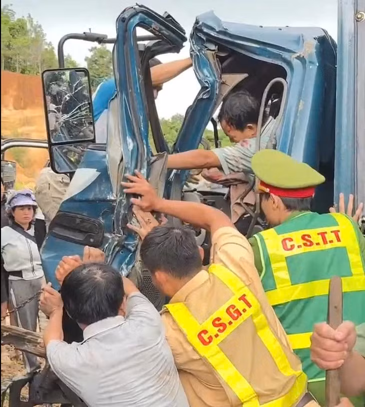 Công an, người dân hợp sức giải cứu tài xế bị mắc kẹt trong cabin bẹp rúm sau vụ tai nạn ở Quảng Ngãi - Ảnh: T.M.