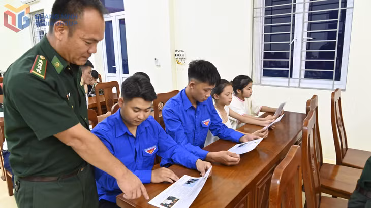 Cán bộ Biên phòng phát tờ rơi tuyên truyền cho nhân dân xã Hải Sơn.