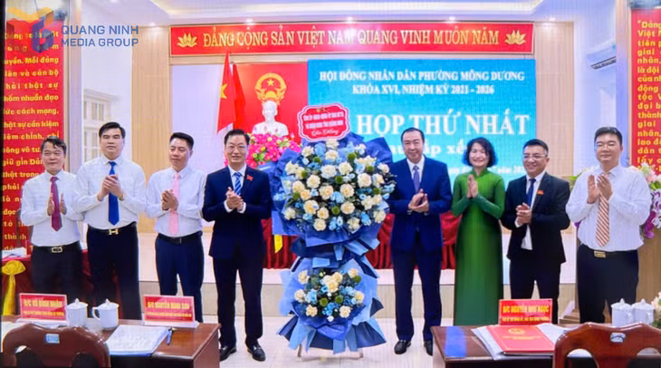 Lãnh đạo phường Mông Dương nhận hoa chúc mừng.