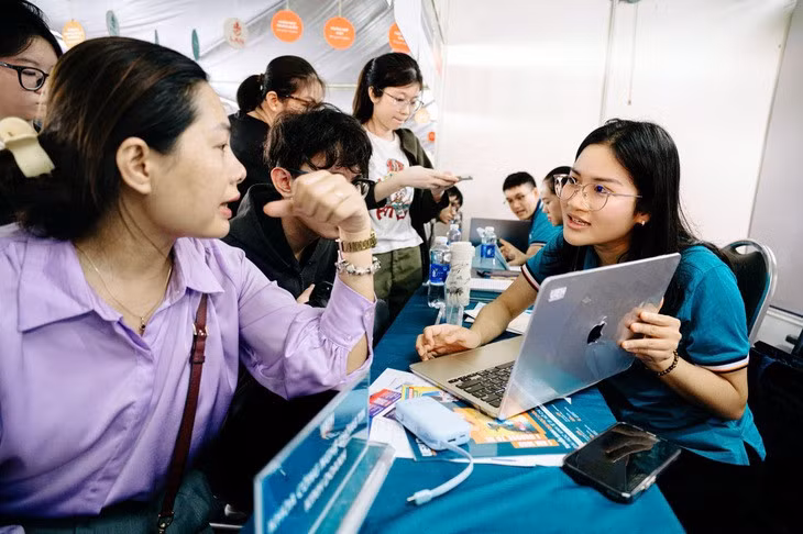 Phụ huynh và học sinh tìm hiểu về cách thức đăng ký xét tuyển tại một gian tư vấn trong Ngày hội lựa chọn nguyện vọng xét tuyển 2025 - Ảnh: THANH HIỆP