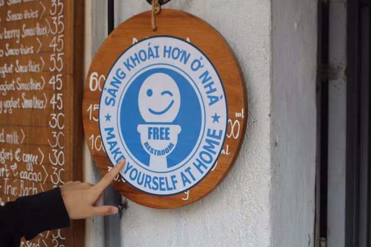 Tấm biển màu xanh có dòng chữ “Free Restroom” thông báo địa điểm đặt nhà vệ sinh miễn phí tại Hà Nội. Ảnh: Lê Tuyến