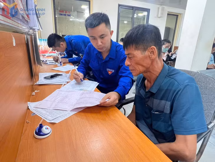 Anh Đàm Quang Châu hướng dẫn người dân làm thủ tục hành chính tại Trung tâm phục vụ Hành chính công phường Quảng Yên.