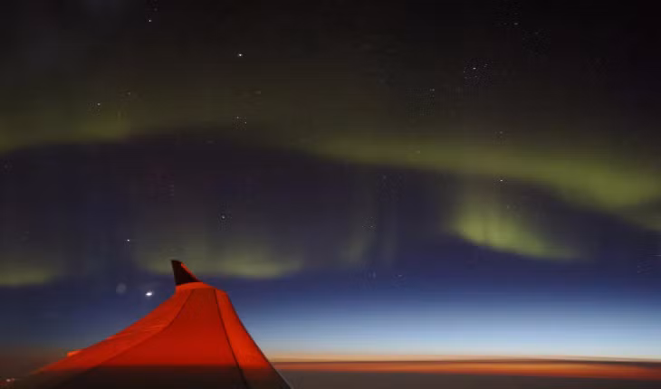 Chiếc máy bay chở khách bay đến châu Âu ngày 28/4/2023, khi bay qua bờ biển phía nam của Greenland du khách đã chứng kiến cảnh cực quang như "nhảy múa" trên bầu trời. Ảnh: Jim Urquhart/Reuters.