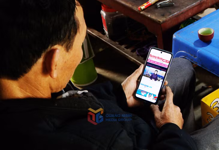 Người dân khu 10, phường Mông Dương, TP Cẩm Phả theo dõi truyền hình trên điện thoại.
