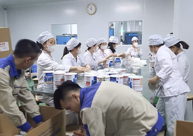 Công nhân đóng hộp thành phẩm sữa giả tại cơ sở sản xuất, chuẩn bị bán ra thị trường. Ảnh: CAND