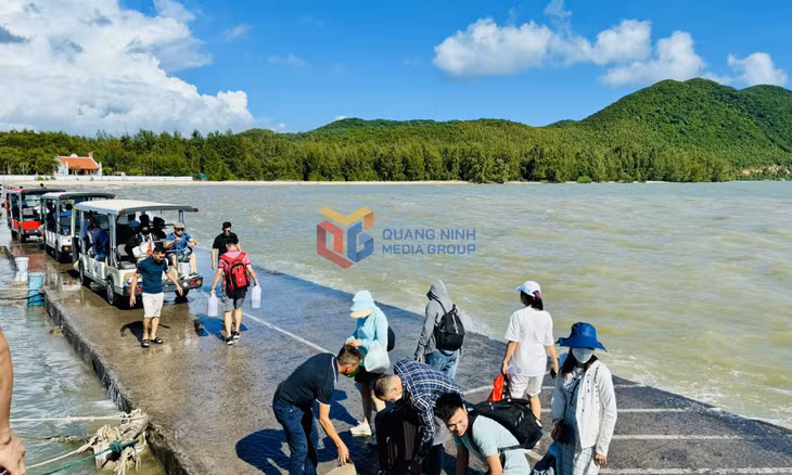 Khách du lịch di chuyển khó khăn trên bến cập tàu Quan Lạn do nước thủy triều ngập (Ảnh chụp tháng 8/2024). Ảnh: Mạnh Trường